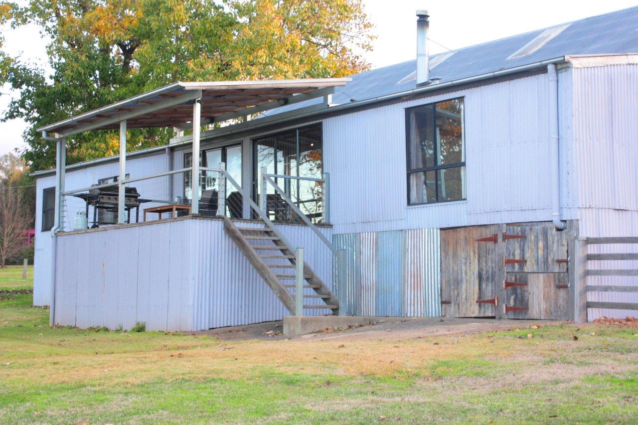 A view of the Woolshed from the back with verandah and corrugated steel panels.
